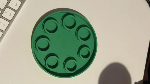 A green circular prototype on a desk